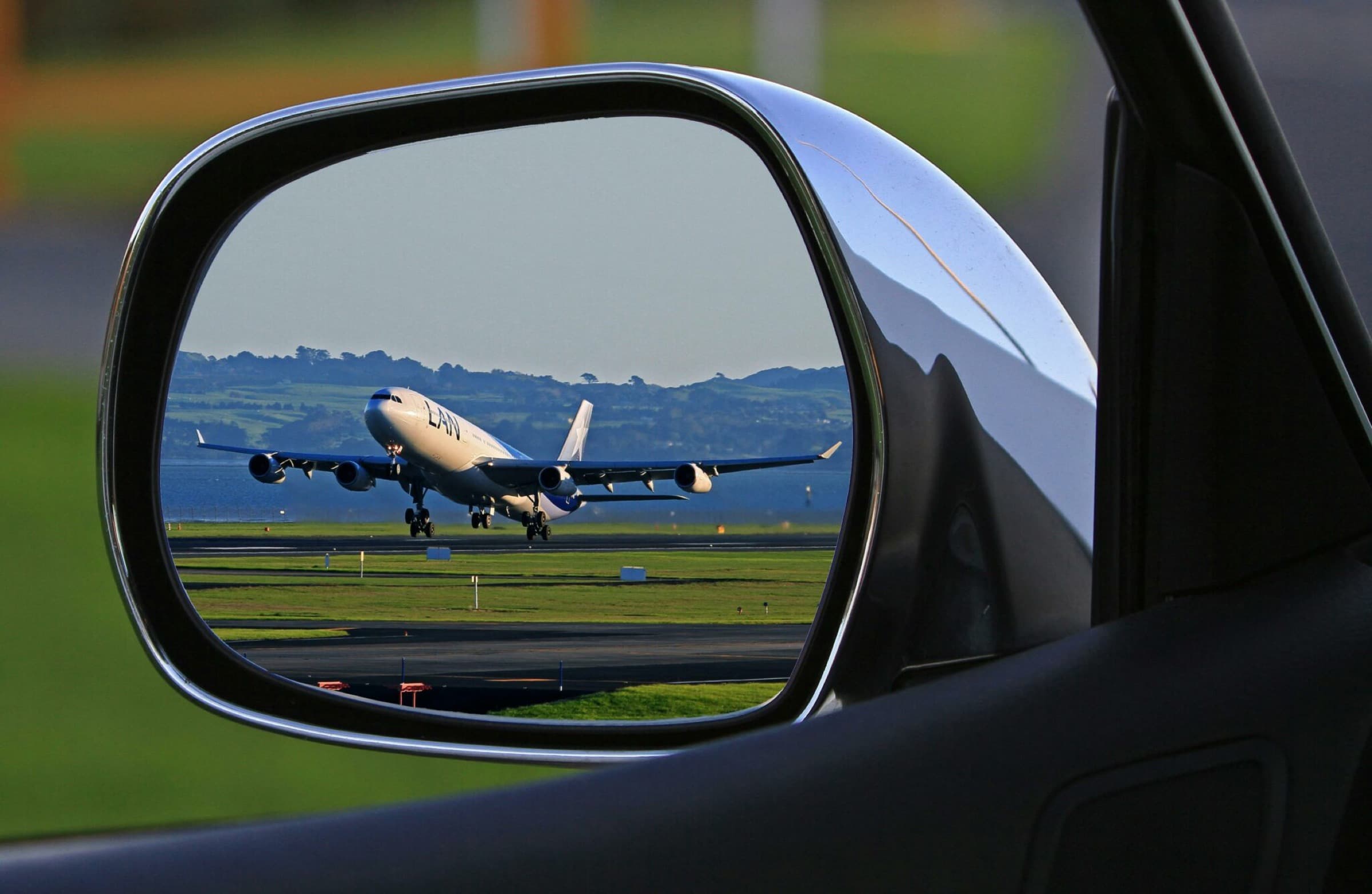 Aeroplane visible in the mirror of a car